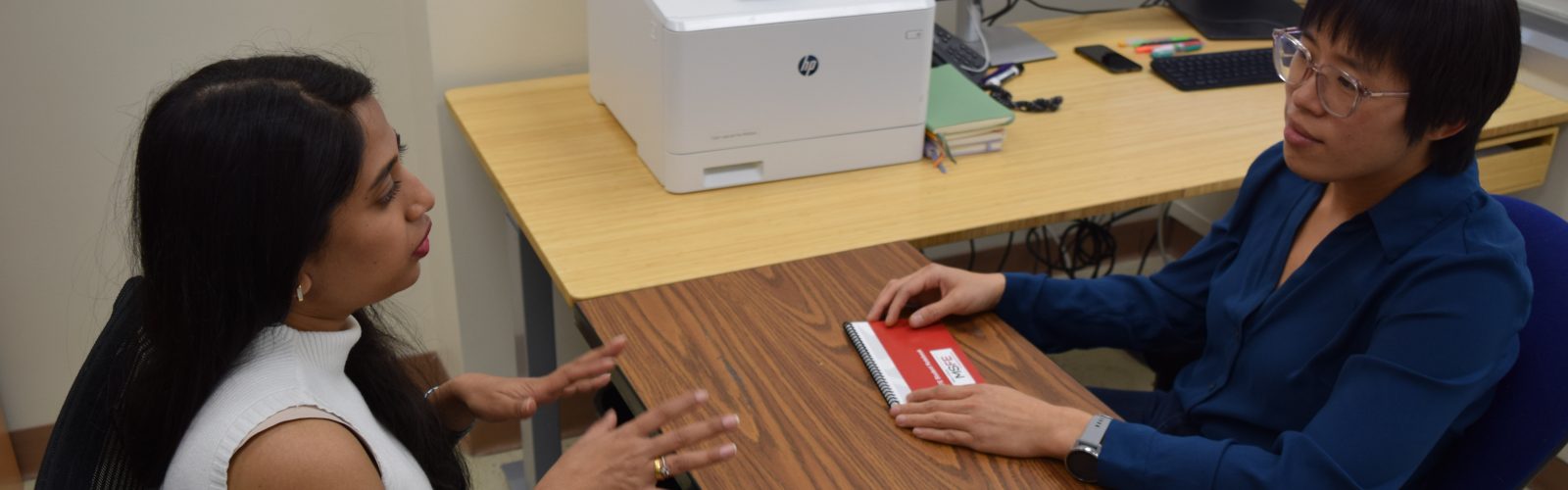 a student and advisor have a discussion in their office