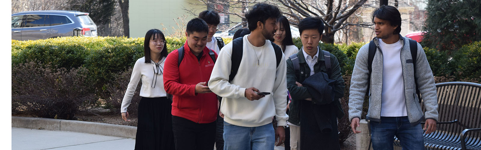 students walk in a group outside and talk with one another